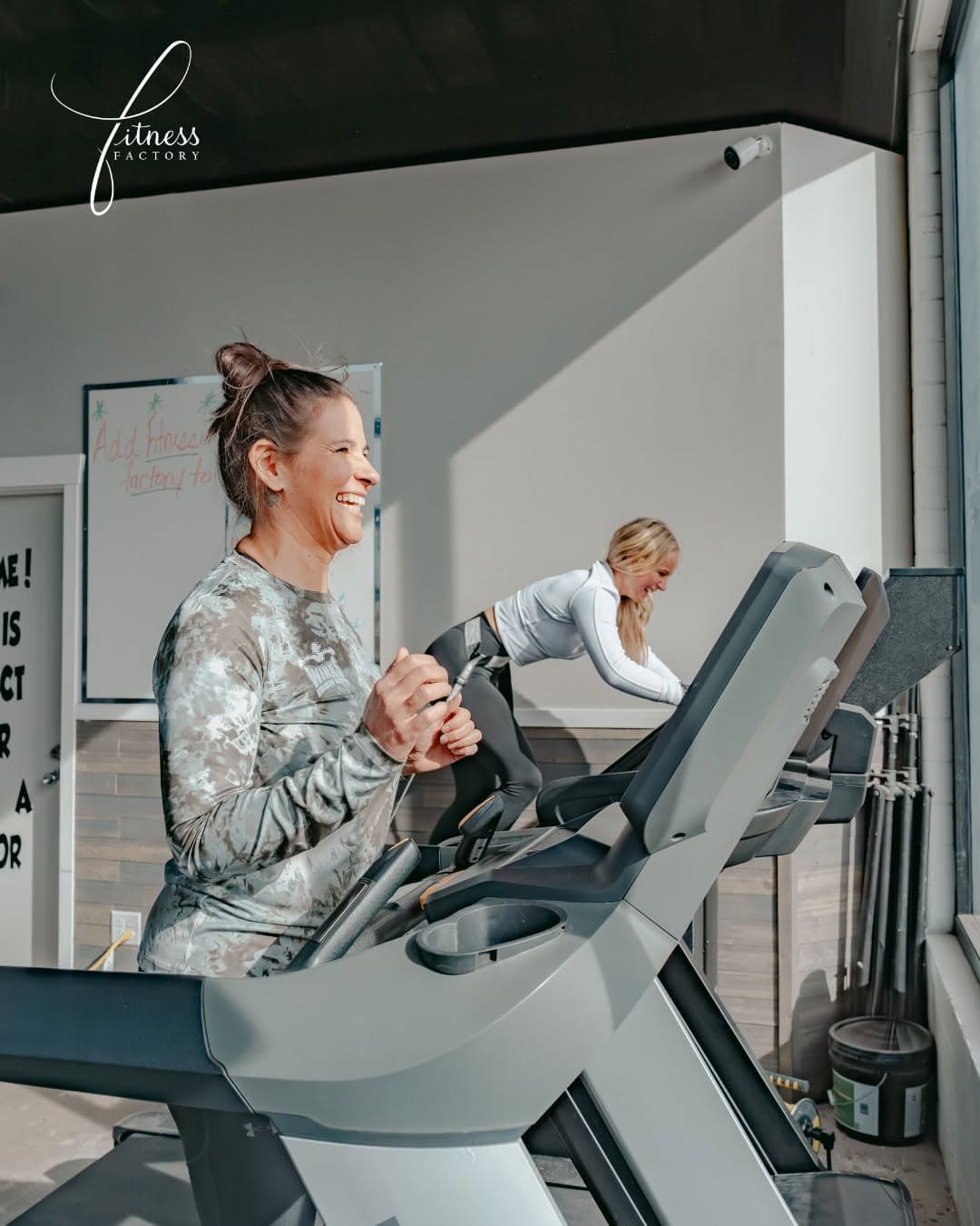 Coach and client sharing a light moment during a treadmill session